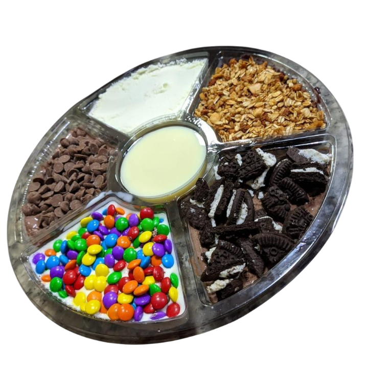 Petisqueira com cinco divisórias, contendo açaí e complementos, como confete, biscoito, granola e leite condensado no centro das divisórias.